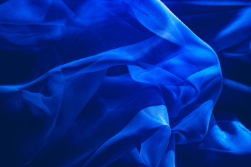 background image of a blue light translucent fabric with pleats. the view from the top.
