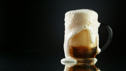 Beer foam overflowing from glass pint
