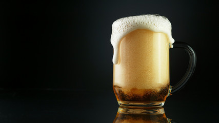 Beer foam overflowing from glass pint