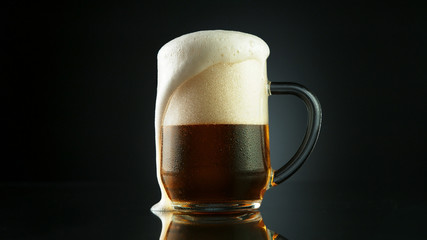 Beer foam overflowing from glass pint