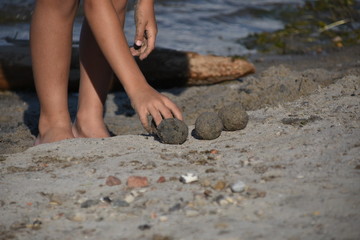 Kind beim Sand-Murmeln formen