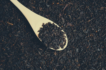 Wooden spoon with sprinkled black tea. Toned.