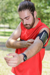 Naklejka premium handsome jogger adjusting his music device