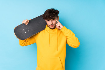 Young arab skater man isolated pointing temple with finger, thinking, focused on a task.