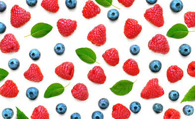 Fototapeta na wymiar Fruit pattern of Raspberries and blueberries with green leaves isolated on white background. Flat lay