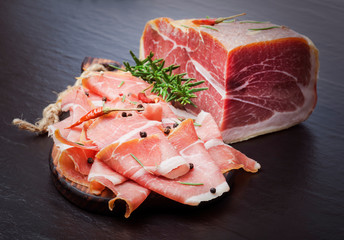 Italian prosciutto crudo or jamon with rosemary. Raw ham.