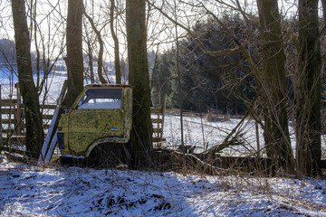 Old abandoned car in the woods, unused for years.