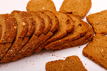Top view of fresh sliced wholegrain or multi grain bread on dark ructic wooden background, close up.