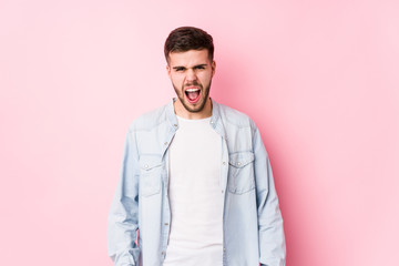 Young caucasian business man posing in a white background isolated screaming very angry and aggressive.< mixto >