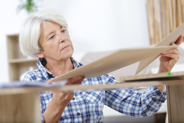 seniro woman assembling wood furniture