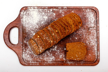 Top view of fresh sliced wholegrain or multi grain bread on dark ructic wooden background, close up.