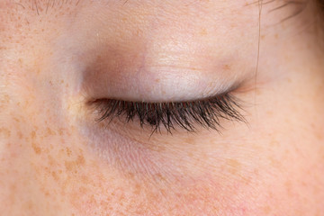 Macro of a closed and relaxed girl eye, details of the eyelid in relief