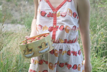 dziewczyna w letniej sukience zbiera truskawki w ogrodzie  - obrazy, fototapety, plakaty