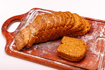 Top view of fresh sliced wholegrain or multi grain bread on dark ructic wooden background, close up.