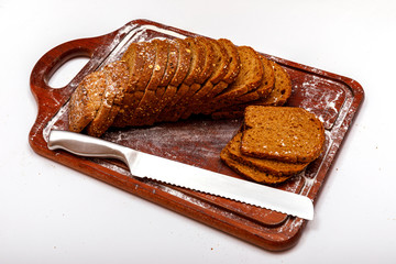 Top view of fresh sliced wholegrain or multi grain bread on dark ructic wooden background, close up.