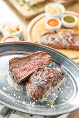 Grilled fillet steaks. A piece of meat cut in two. Barbecue restaurant menu. On a metal plate with coal. Chateaubriand Steak