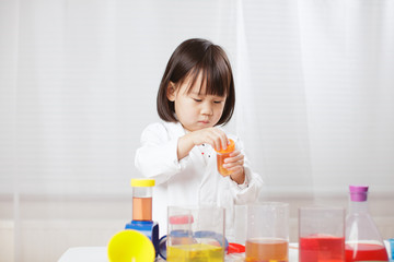 toddler girl pretend play  scientist  role  at home against white background