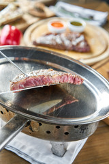 Grilled striploin steak. The strip steak or New York strip On a metal plate with coal. Barbecue restaurant menu.