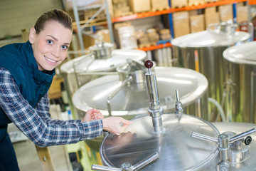 portrait of woman by stainless steel vats