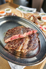 Grilled striploin steak. The strip steak or New York strip On a metal plate with coal. Barbecue restaurant menu.