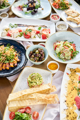 Many different delicious dishes dishes on the table. Various snacks and antipasti on the table. Restaurant menu. Italian cuisine