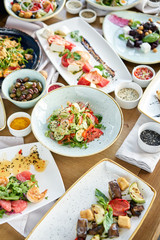 Many different delicious dishes dishes on the table. Various snacks and antipasti on the table. Restaurant menu. Italian cuisine