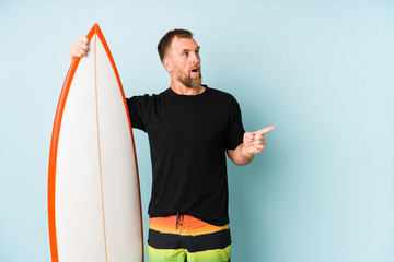Surfen man isolated on blue background pointing to the side