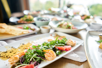 Fresh salad with grilled shrimps, slice grapefruit and arugula salad and spicy fried prawns. Restaurant menu, natural and organic food concept.
