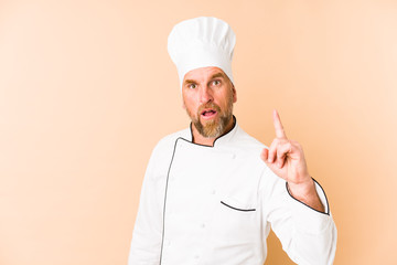 Chef man isolated on beige background having an idea, inspiration concept.