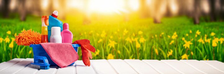 Cleaning supplies and chemicals on nature background web banner: spring cleaning concept
