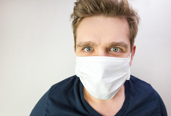 Man with mask to protect him from virus. The concept of the epidemic of the coronavirus. Tired Doctor with medical white mask.