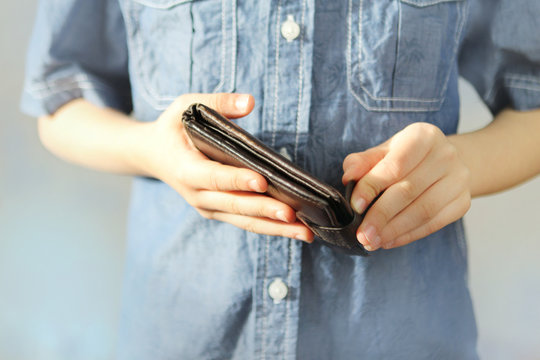 kid holds a wallet in his hand, trying to open with his fingers, the concept of pocket money, theft, shopping