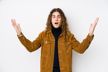 Long hair man posing isolated receiving a pleasant surprise, excited and raising hands.