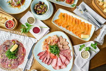 Beef tartar in the restaurant. Variety of dishes on the table. Various snacks and antipasti on the table. Restaurant menu. Italian cuisine
