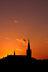 Fototapeta premium Church building exterior in silhouette of sunrise or sunset with glowing sunlight