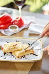 Woman eats Latin American fried empanadas with Vegetable salad with arugula. Decorated with balsamic sauce. Menu restaurant