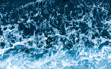 Background shot of aqua sea water waves surface. Blue ocean water and foam aerial view.