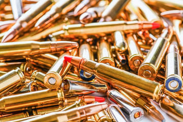 Pile of fire bullets or ammunition on whitetable. Many various projectiles into gun top view. - obrazy, fototapety, plakaty