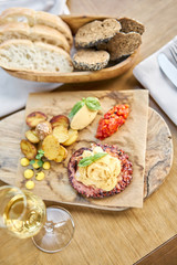 Roasted octopus BBQ and Baked potato with a glass of Grapa. Wooden plate. Restaurant menu