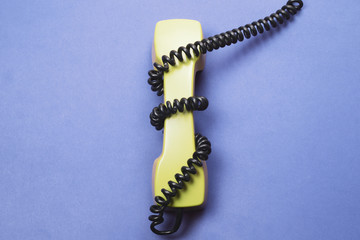 Vintage telephone handset. phone receiver on blue background. old communication technology. copy space