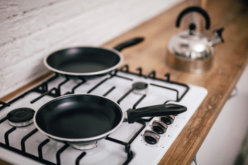 two black pans stand on the stove