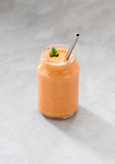 Carrot smoothie cocktail with banana and oatmeal in a jar