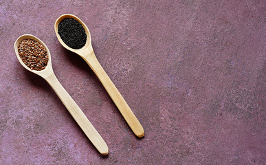 Two wooden spoons filled with Basil and flax seeds lie on a lilac background. Close-up, copy space..