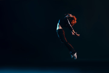 Fototapeta na wymiar brunette girl shows different dance elements on a dark background