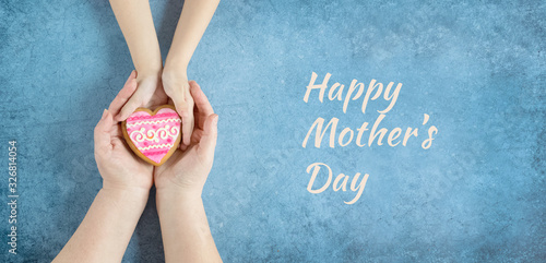 Happy mother's day.Heart in the hands of daughter and mother on a blue background.I love you.Love and health in the family.Banner for the store.Greeting card.Women's day.