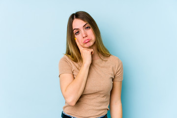 Fototapeta premium Young caucasian woman isolated on blue background crying, unhappy with something, agony and confusion concept.