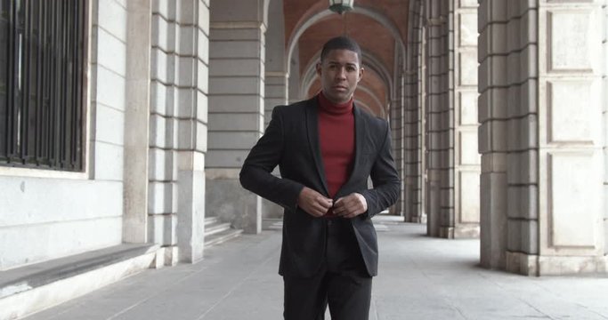 attractive black Hispanic young guy male businessman successful manager in a classic suit follows the camera cinematic shot