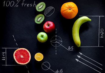 fruits on chalkboard. geometry sketches and ripe fruits with hand letters 100 percent fresh. healthy food, restaurant or cafe concept.