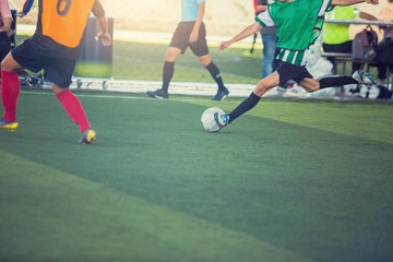 Obraz premium Selective focus to soccer player speed run to control and shoot ball to goal. Soccer players fighting each other by kicking the ball.