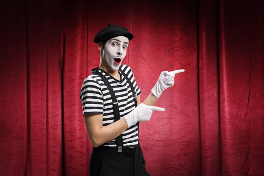 Pantomime man performing in a theater with red curtains
